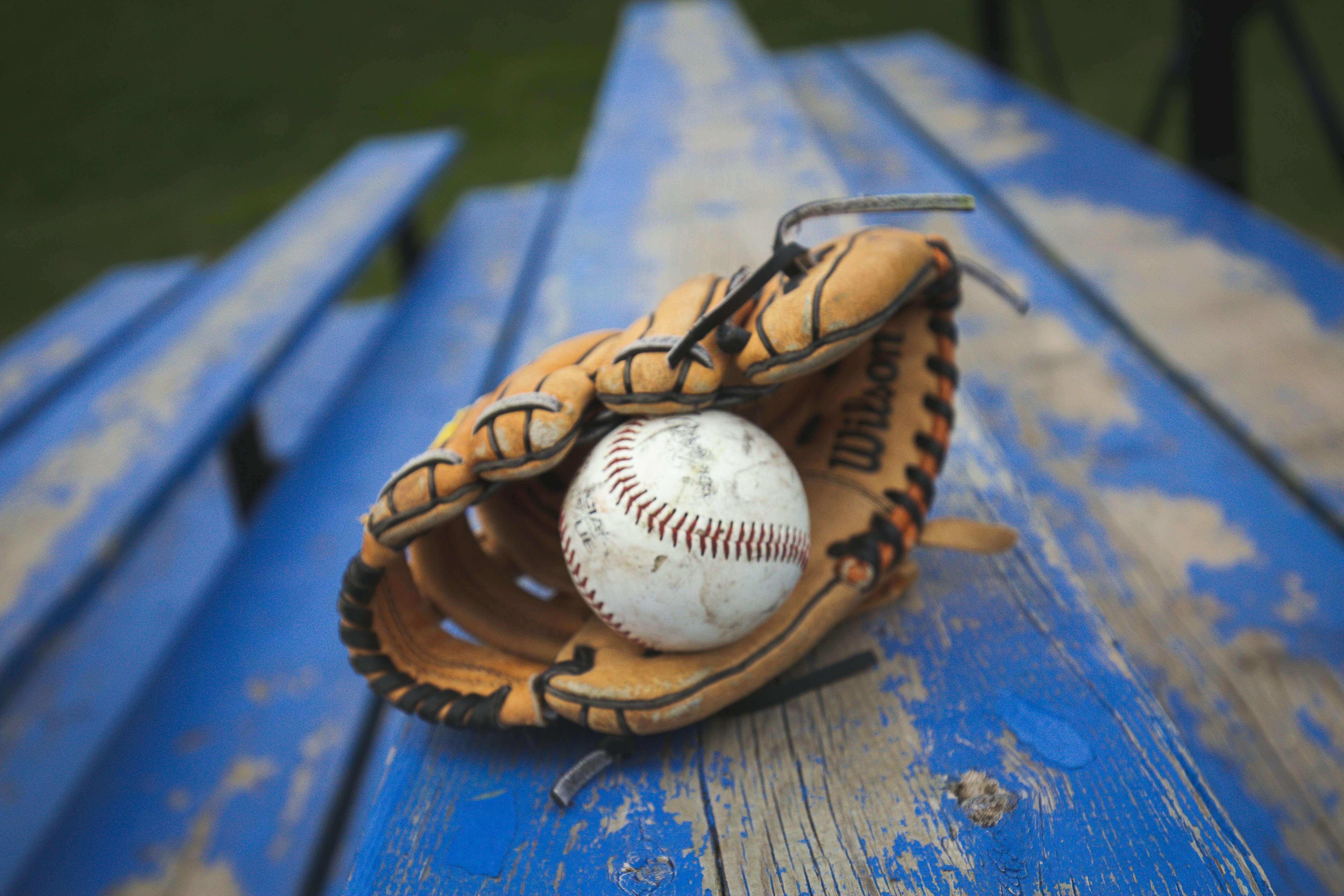 Baseball glove lying on blue bleachers. 